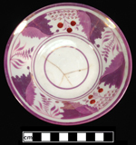 Bone china saucer with purple and pink luster and red overglaze painted berries. 